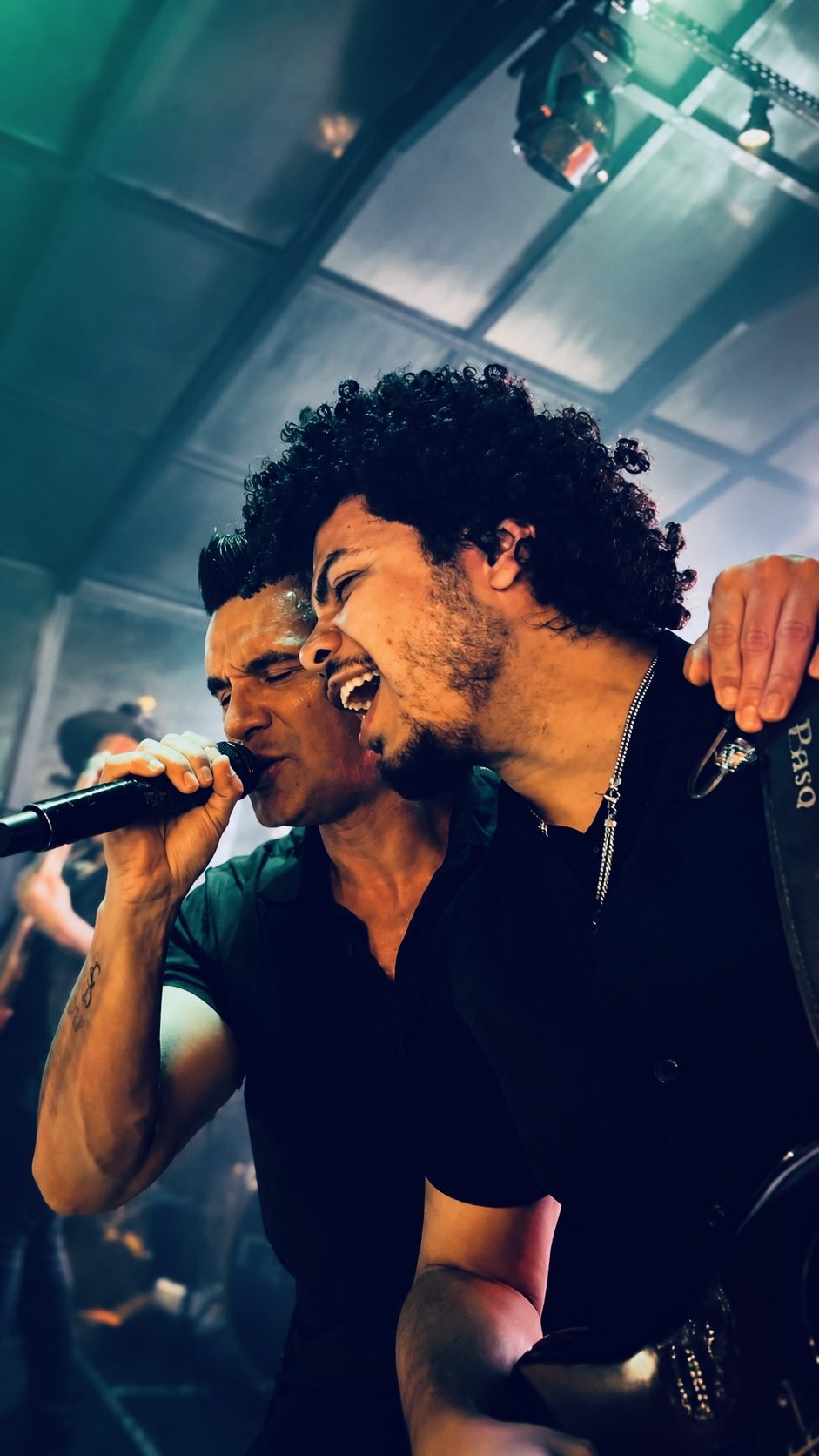 Dois vocalistas da Banda iNova cantando juntos com energia no palco
