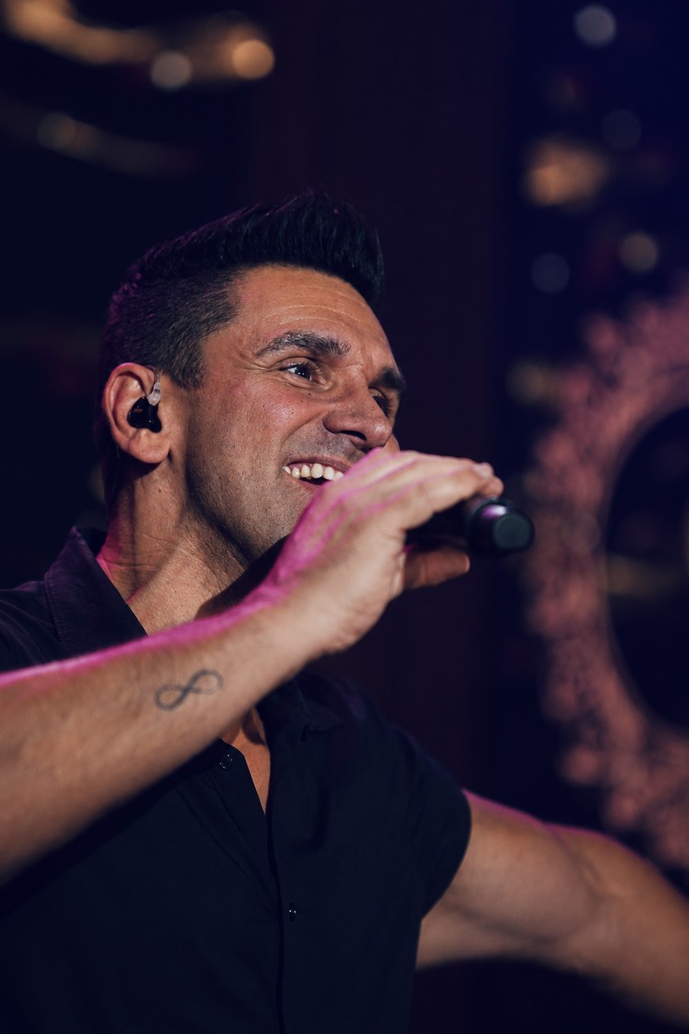 Cantor da Banda iNova sorrindo ao microfone durante o show