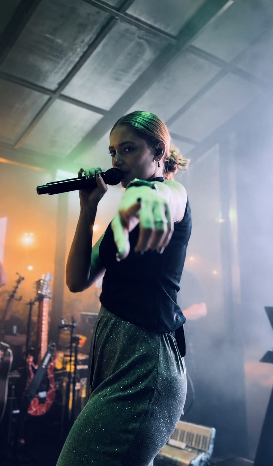 Cantora da Banda iNova cantando sob iluminação de palco