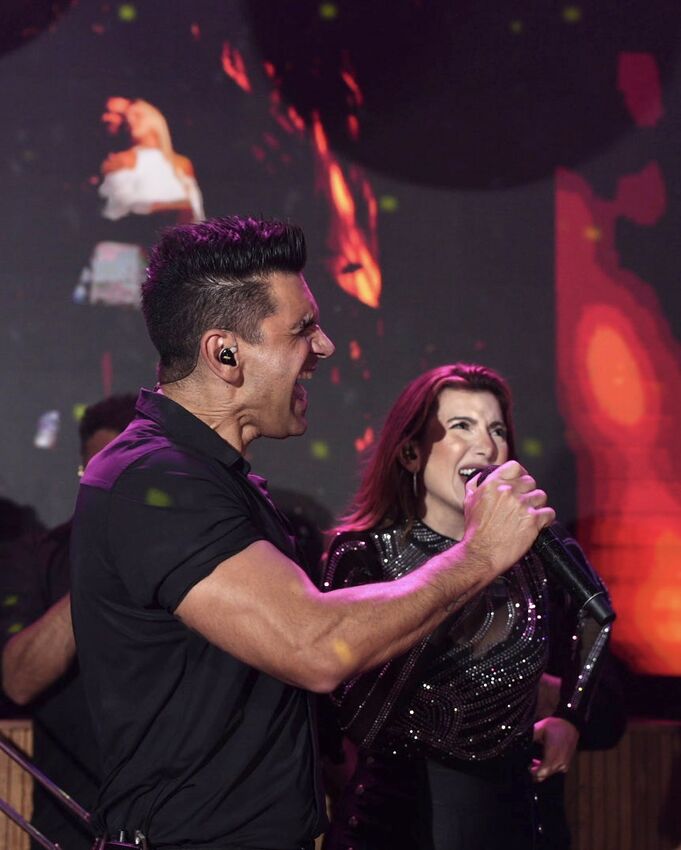 Casal de vocalistas da Banda iNova em performance romântica no palco